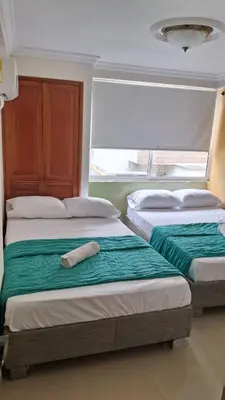 two beds sitting next to each other in a bedroom at apartamento en marbella dúplex, cerca centro histórico - 3 in Cartagena de Indias