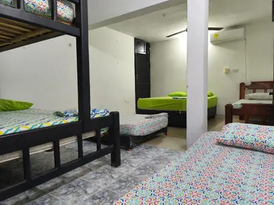 a room with three bunk beds and a table at Las Margaritas Frente al Mar 1 in Coveñas