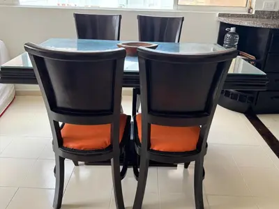 a dining room table with black chairs with orange seats at Laguito Beach Cartagena in Cartagena de Indias