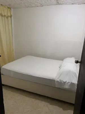 a bed in a room with a white wall at Apartamento Goyo en Coveñas in Coveñas