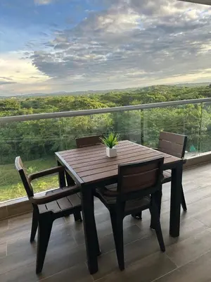 a wooden table and chairs on a balcony at Baia Kristal Kabo Apartamento in Cartagena de Indias