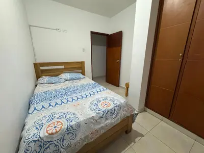 a bedroom with a bed with a blue and white comforter at Un lugar cómodo y acogedor in Barranquilla