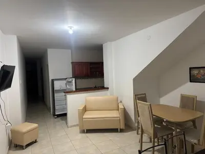 a living room with a table and chairs and a kitchen at Un lugar cómodo y acogedor in Barranquilla