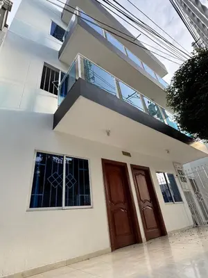 a white house with two doors and a balcony at Un lugar cómodo y acogedor in Barranquilla