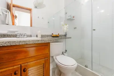 a white bathroom with a toilet and a shower at Loft in Old Town, Cartagena in Cartagena de Indias