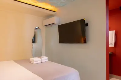 a room with a bed with a flat screen tv at Casa Stella Rooms in Cartagena de Indias