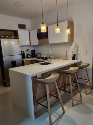 a kitchen with a sink and a counter with stools at Hermoso apartamento familiar in Cartagena de Indias