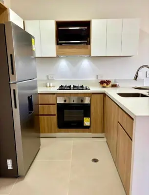a kitchen with a stainless steel refrigerator and wooden cabinets at Hermoso apartamento familiar in Cartagena de Indias