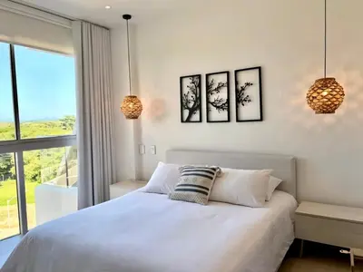 a bedroom with a white bed with three pictures on the wall at Hermoso apartamento familiar in Cartagena de Indias