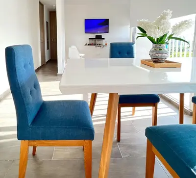 a dining room with a white table and blue chairs at Apartamento Ideal cerca de Zona Industrial, Terminal y Centro Comercial in Cartagena de Indias