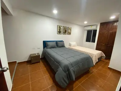 a bedroom with a large bed and a small bed sidx sidx sidx sidx at Modern duplex 5 minutes from the Historic Center in Cartagena de Indias