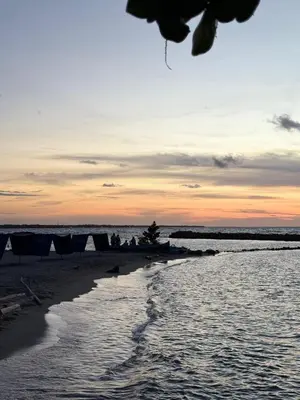 a beach with chairs and the ocean at sunset at Amari Ocean House in Coveñas