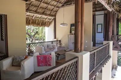 a balcony with white chairs and a table on a house at Villa Frente al mar en el Calao, San Antero in Calao