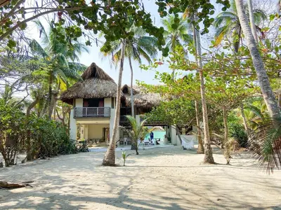 a house on the beach with palm trees at Villa Frente al mar en el Calao, San Antero in Calao