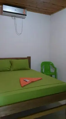 a bedroom with a green bed and a green chair at Playas el paraiso in San Bernardo del Viento