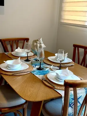 a wooden table with plates and wine glasses on it at Beach house in Cartagena de Indias