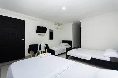 a hotel room with two beds and a tv at Hotel Costa Caribe BAQ in Barranquilla