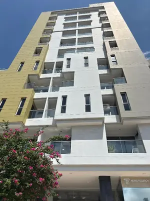 a tall building with pink flowers in front of it at Apartamento en la mejor zona de Barranquilla in Barranquilla