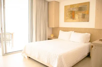 a bedroom with a white bed and a large window at Charming Oceanfront Apartment with Balcony and Panoramic view, Cartagena Colombia in Cartagena de Indias