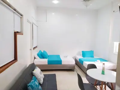 a small room with two beds and a table at apto en casa centro historico 3 piso in Cartagena de Indias