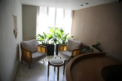 a living room with two chairs and a table and a window at Enjoy the sun and beach in our apartment in Cartagena de Indias