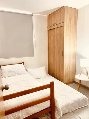 a bedroom with a bed and a wooden cabinet at Enjoy the sun and beach in our apartment in Cartagena de Indias