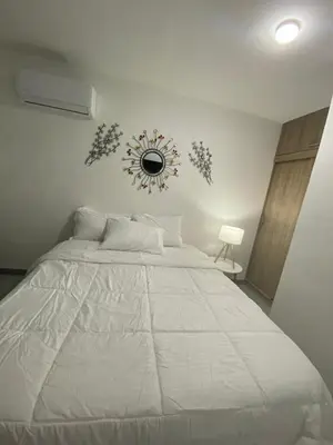 a bedroom with a large white bed with a clock on the wall at Enjoy the sun and beach in our apartment in Cartagena de Indias