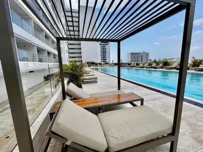 a balcony with a table and chairs and a swimming pool at Loft Vistas Mar. Crespo Piscina y Jacuzzi in Cartagena de Indias