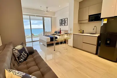 a kitchen and a living room with a bed and a couch at Loft Vistas Mar. Crespo Piscina in Cartagena de Indias