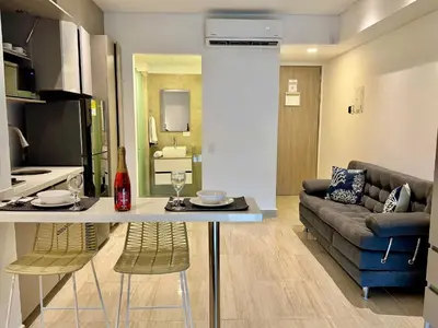 a kitchen and living room with a table and a couch at Loft Vistas Mar. Crespo Piscina in Cartagena de Indias