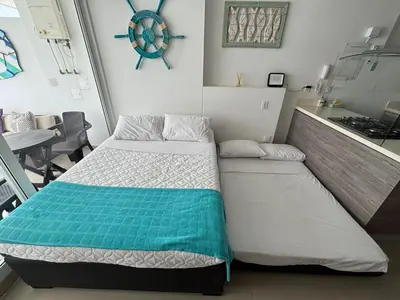 a small bedroom with a bed and a kitchen at Apto con playa, hotel y piscina in Santa Marta