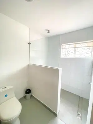 a white bathroom with a toilet and a window at Espacioso Apto Moderno! Excelente Ubicación Norte de Barranquilla in Barranquilla