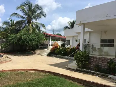 a house with a palm tree in front of it at Espectacular casa, vista al mar y piscina privada in Santa Veronica