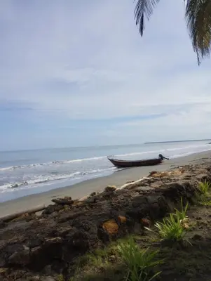 a boat sitting on a beach next to the ocean at San Bernardo del Viento Cabaña La Isabela in San Bernardo del Viento