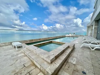 a swimming pool with a view of the ocean at Oceanview Bocagrande Laguito Palmetto Sunset Building in Cartagena de Indias