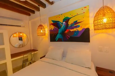a bedroom with a bed and a painting on the wall at Casa Bali Castillo View Private Pool & Rooftop, Near Historic Center in Cartagena de Indias