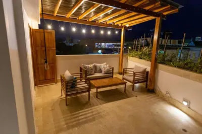 a patio with a couch and a table and chairs at Blue House Castillo View Private Jacuzzi & Colonial Balconies in Cartagena de Indias