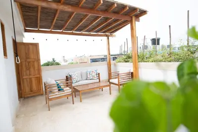 a patio with two benches and a wooden pergola at Blue House Castillo View Private Jacuzzi & Colonial Balconies in Cartagena de Indias