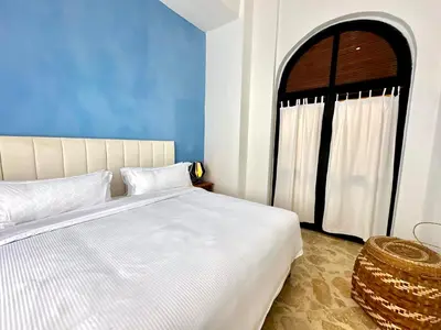 a bedroom with a large white bed and a window at Calamari Homes - El Porvenir 305 - Walled city in Cartagena de Indias