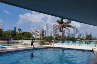 a man walking in a swimming pool with a city at Vista Divisadero 25 in Cartagena de Indias