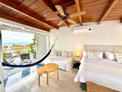 a room with two beds and a hammock in it at by Calamari Homes-Plaza Bolivar Penthouse Sea view in Cartagena de Indias