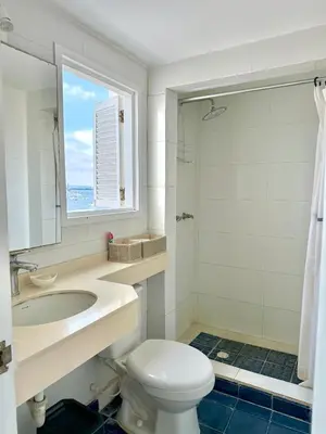 a bathroom with a toilet and a sink and a window at by Calamari Homes-Plaza Bolivar Penthouse Sea view in Cartagena de Indias