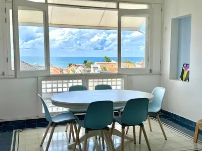 a table and chairs in a room with a view of the ocean at by Calamari Homes-Plaza Bolivar Penthouse Sea view in Cartagena de Indias