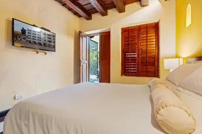 a bedroom with a white bed and a television at Reve hotel in Cartagena de Indias