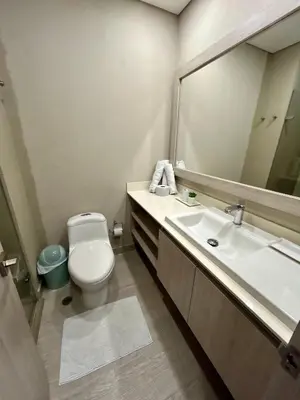 a bathroom with a toilet and a sink and a mirror at Exclusivo apartamento en Cielo Mar - Américas 609 in Cartagena de Indias