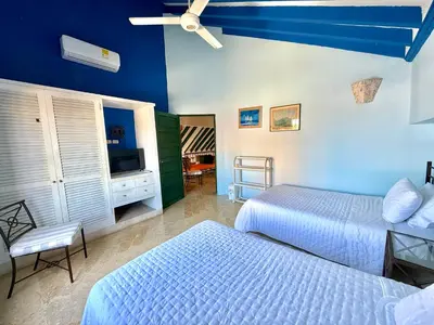 a bedroom with two beds and a television in it at by Calamari Homes - El Porvenir 402 walled city in Cartagena de Indias