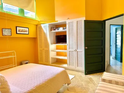 a bedroom with a bed and a yellow wall at by Calamari Homes - El Porvenir 402 walled city in Cartagena de Indias