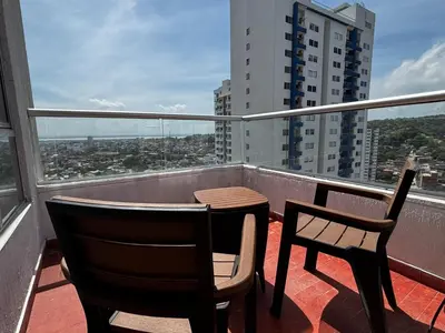 a balcony with two chairs and a table on a roof at Apartamento amoblado, cómodo y cerca de lo mejor de la ciudad in Cartagena de Indias