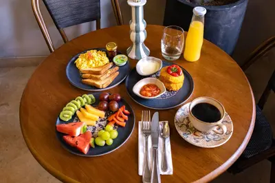 a wooden table with plates of breakfast food on it at Hotel Casa Bianca by Faranda Boutique in Cartagena de Indias