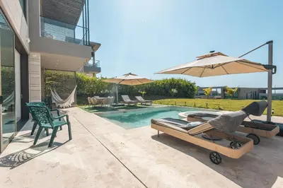 a backyard with a swimming pool with a chair and an umbrella at 4BR Caribbean Deluxe Villa 3C in Cartagena de Indias